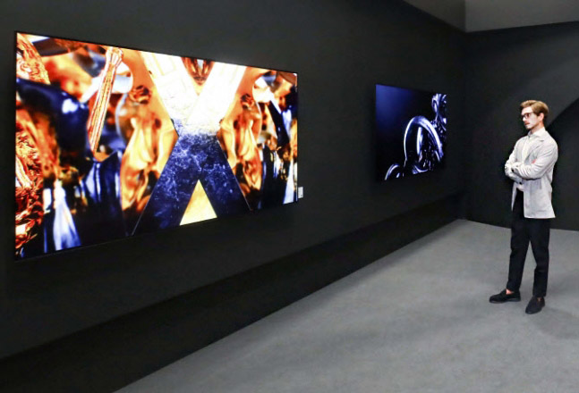  LG전자 모델이 ‘프리즈 서울’에서 LG 올레드 TV와 함께 전시된 작가의 예술 작품을 감상하고 있다. / 사진=LG전자 제공
